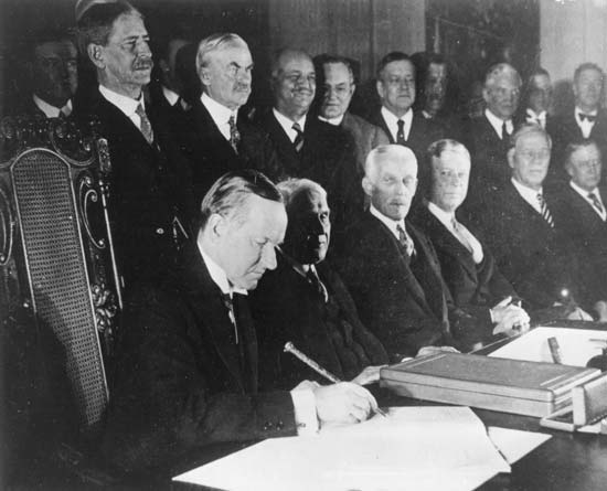 President Coolidge signs the Kellogg-Briand Pact, January 17, 1929, East Room of the White House.