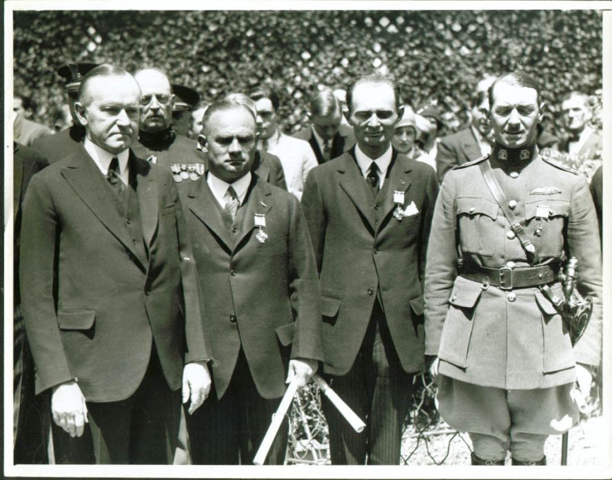President Coolidge honoring the aviation pioneers of the Junker "Bremen" for the first East to West transatlantic crossing accomplished in April 1928. Here the crew, L to R: Captain Hermann Kohl, Baron von Huenefeld (both of Germany), and Major James C. Fitzmaurice of Ireland, are bestowed the Distinguished Flying Cross, the highest award in aviation, by President Coolidge at the White House, May 1928. 